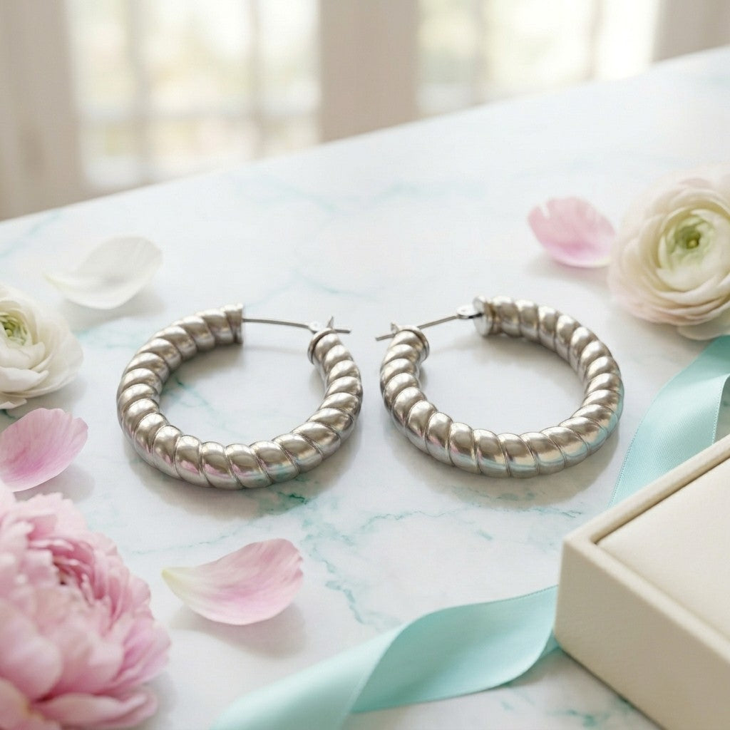 Aramat Jewels silver-colored hollow steel hoop earrings with a ribbed stripe motif, 30mm diameter.