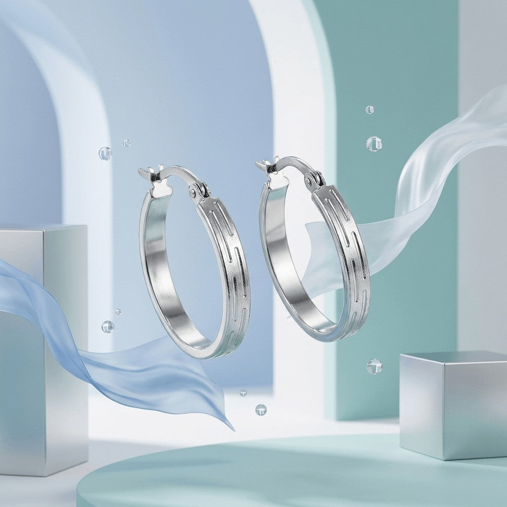 Aramat Jewels silver-tone stainless steel hoop earrings with a subtle striped pattern, 20mm diameter.