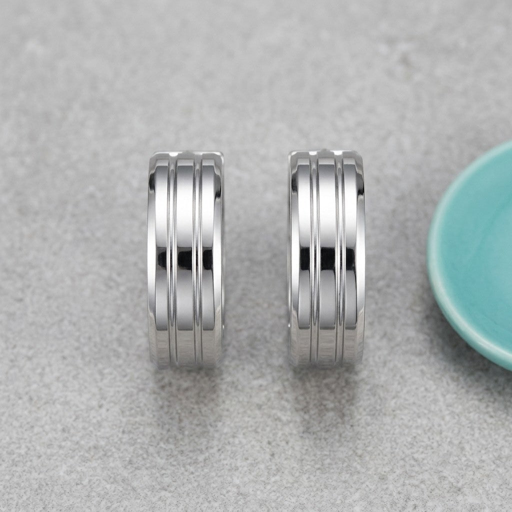 Aramat Jewels silver-tone stainless steel hoop earrings with three raised vertical stripes, 20mm diameter.