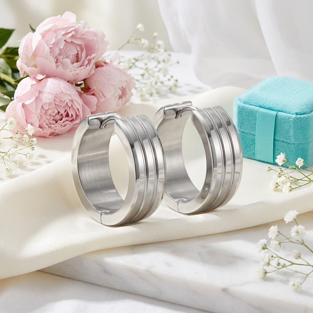 Aramat Jewels silver-tone stainless steel hoop earrings with three raised stripes, 20mm diameter.