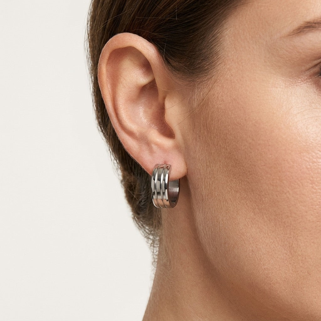 Aramat Jewels silver-tone stainless steel hoop earrings with three raised stripes, 20mm diameter.