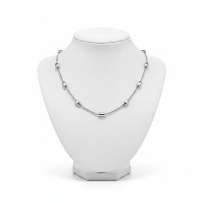Aramat Jewels silver-colored stainless steel necklace with oval bead links on a white jewelry display bust.