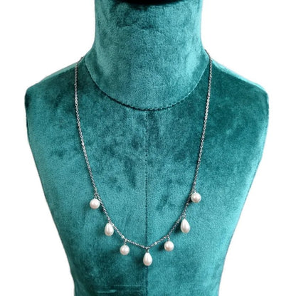 Aramat Jewels silver-tone stainless steel necklace with white synthetic drop and round pearls on a green display bust.