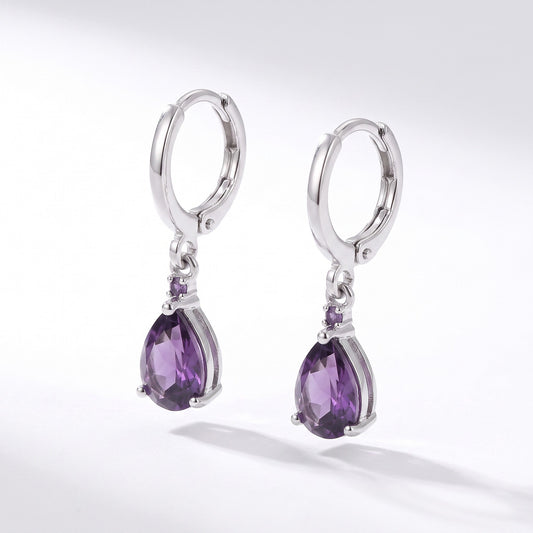 Aramat Jewels silver-tone stainless steel huggie hoop earrings with a dangling purple teardrop zirconia stone.