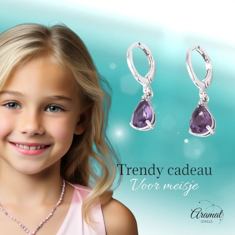 Aramat Jewels silver huggie earrings with dangling purple teardrop zirconia stones, worn by a smiling young girl.