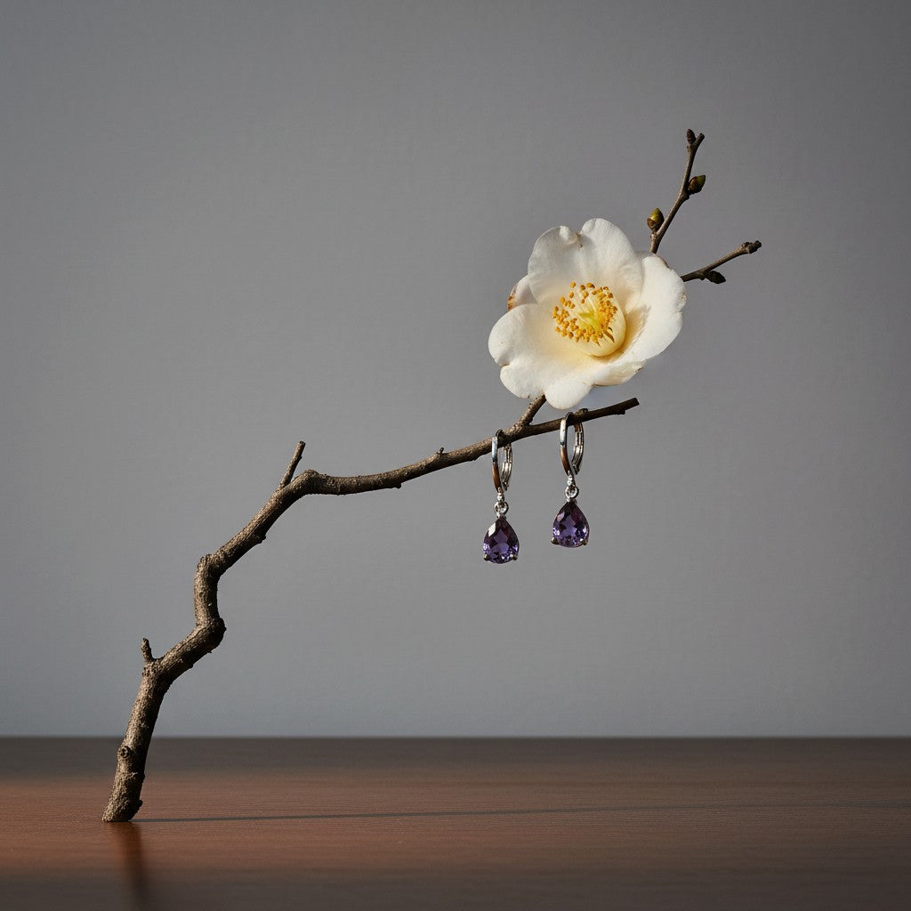 Aramat Jewels silver stainless steel huggie earrings with dangling purple teardrop zirconia stones on a flower branch