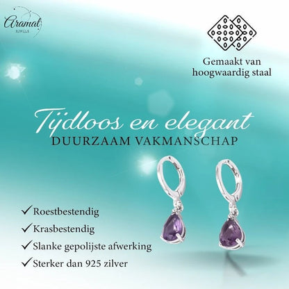 Aramat Jewels silver stainless steel huggie earrings with dangling purple teardrop zirconia stones on a teal background.