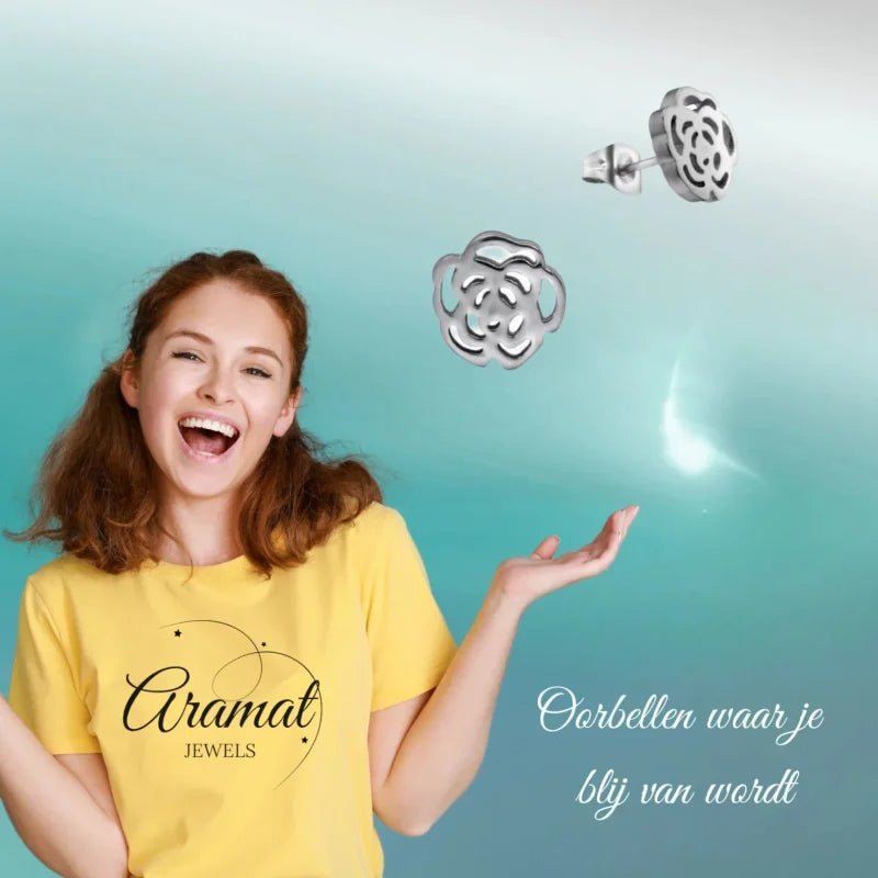 Aramat Jewels silver-colored stainless steel open rose stud earrings worn by a smiling woman in a yellow t-shirt
