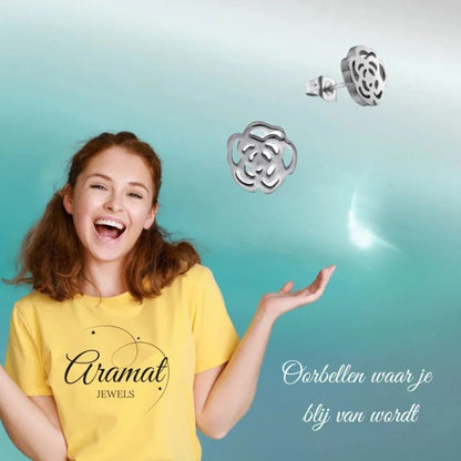 Aramat Jewels silver-colored stainless steel open rose stud earrings worn by a smiling woman in a yellow t-shirt