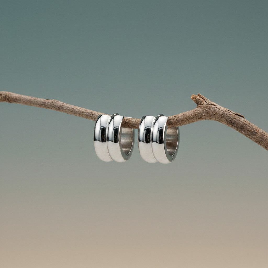 Aramat Jewels silver-colored stainless steel huggie hoop earrings with two rounded stripes, 13mm diameter.