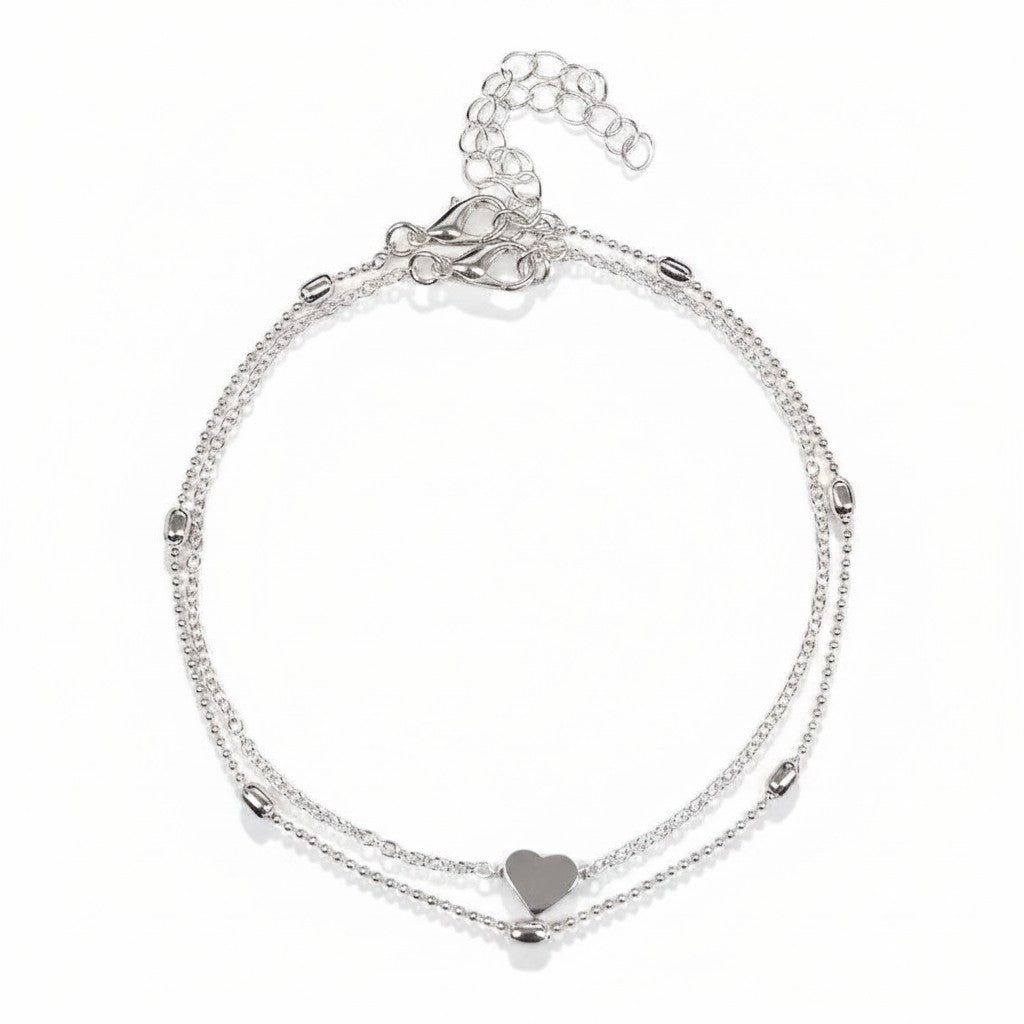 Aramat Jewels silver-colored steel anklet set featuring a delicate heart charm and small decorative beads.