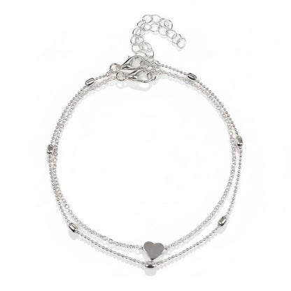 Aramat Jewels silver-colored steel anklet set featuring a delicate heart charm and small decorative beads.