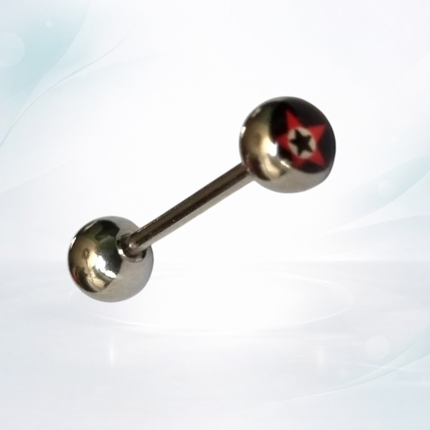 Aramat Jewels silver steel tongue piercing with a black, red, and white star logo on one ball.