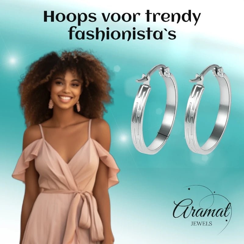 Aramat Jewels silver stainless steel hoop earrings with a striped pattern, 20mm diameter, worn by a smiling woman in a light pink dress.