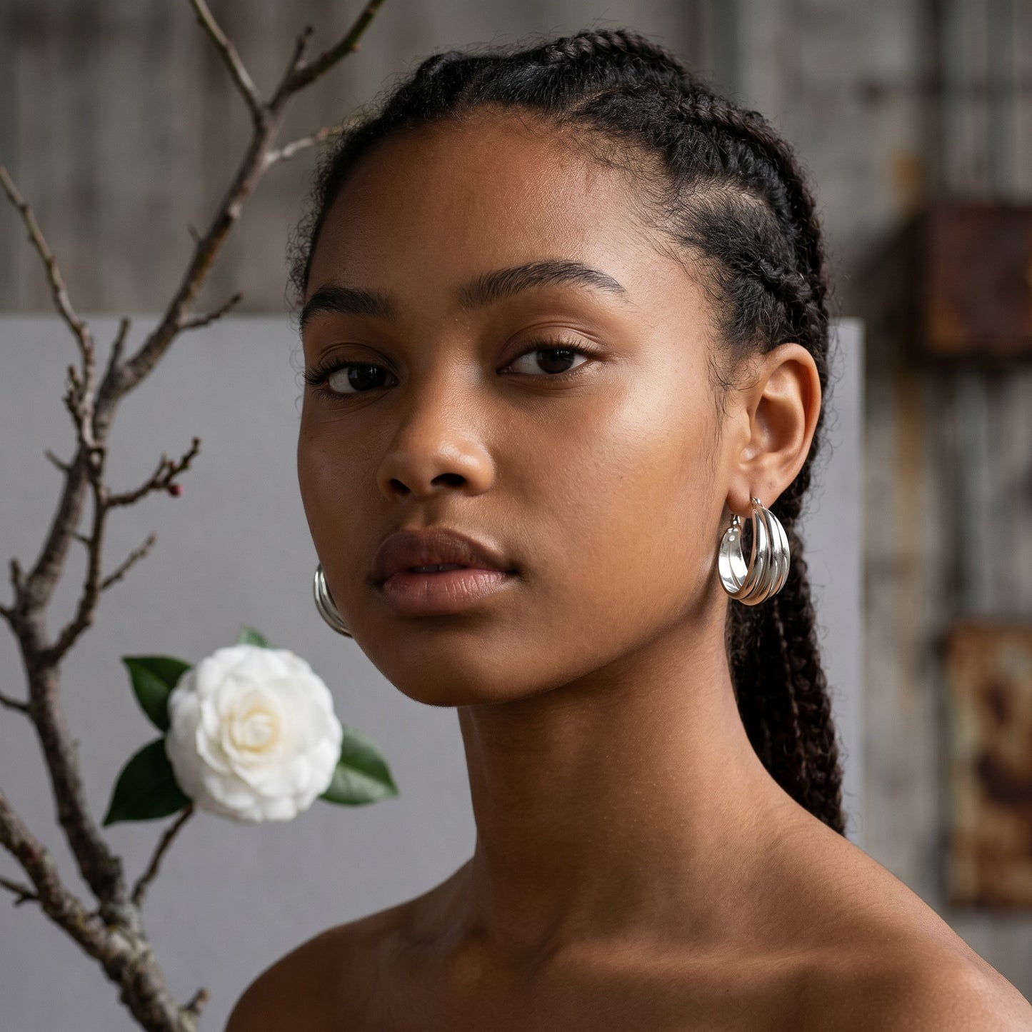 Aramat Jewels silver-tone stainless steel triple hoop earrings, 25x9mm, with a glossy, layered design and a secure hinge closure.