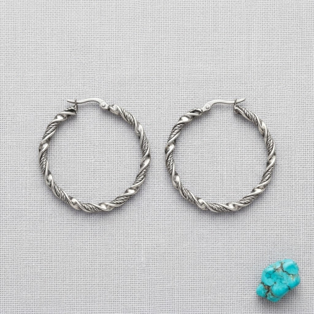 Aramat Jewels silver-tone stainless steel twisted hoop earrings, 30mm or 40mm diameter, 3mm width, with a shiny finish.