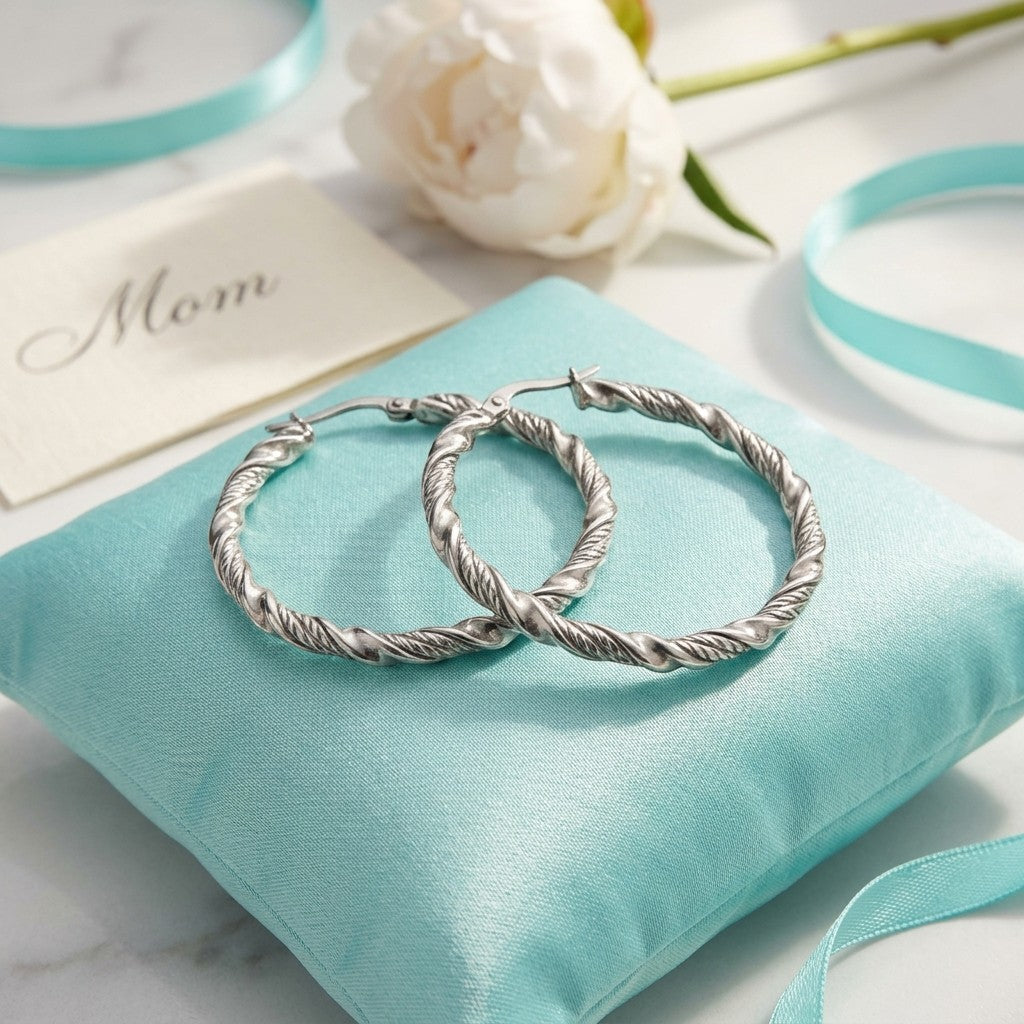 Aramat Jewels silver-tone stainless steel twisted hoop earrings, 30mm or 40mm diameter, with a shiny finish.