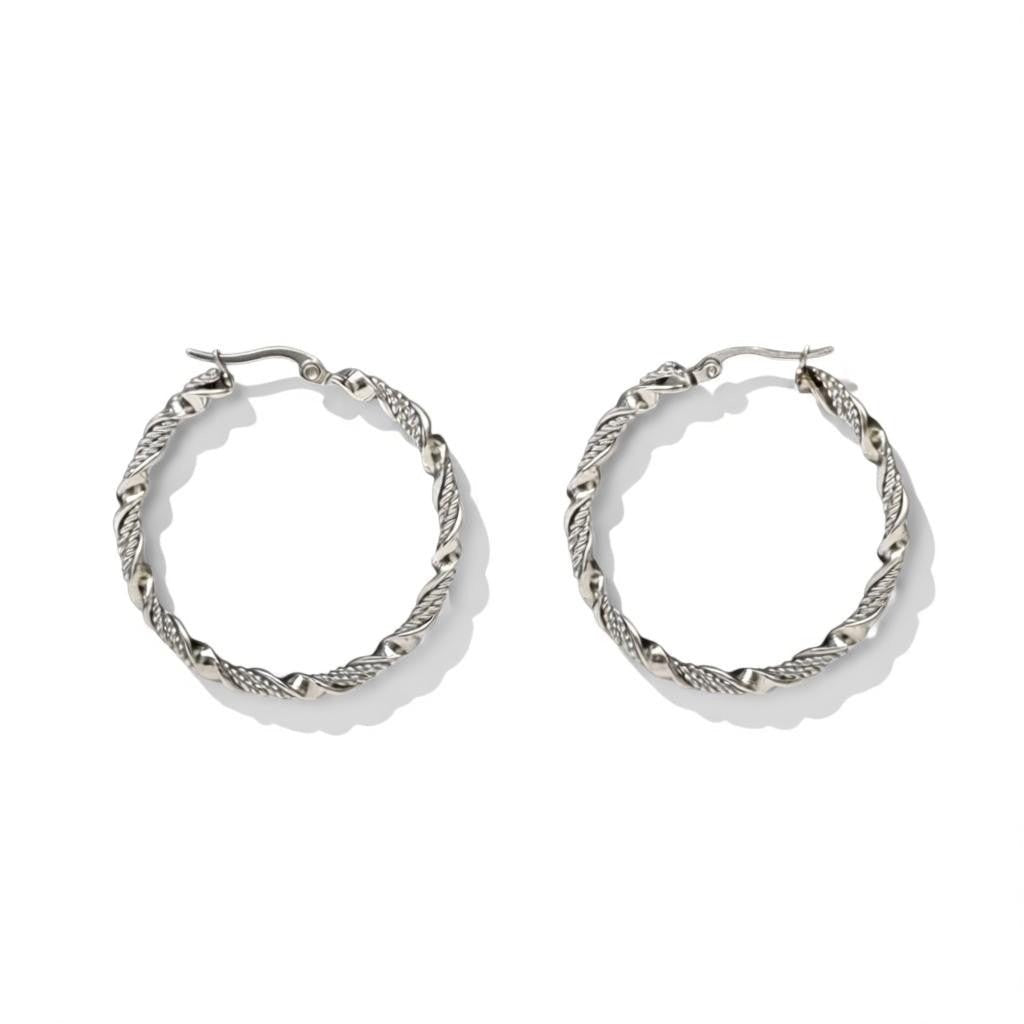 Aramat Jewels silver-tone stainless steel twisted hoop earrings, 30mm or 40mm diameter, 3mm width, with a shiny finish and hinge closure.