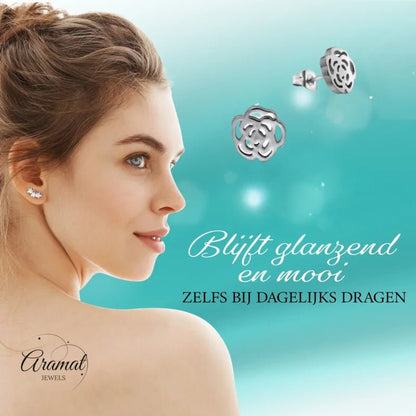 Aramat Jewels stainless steel rose stud earrings with an open design worn by a woman against a blue background
