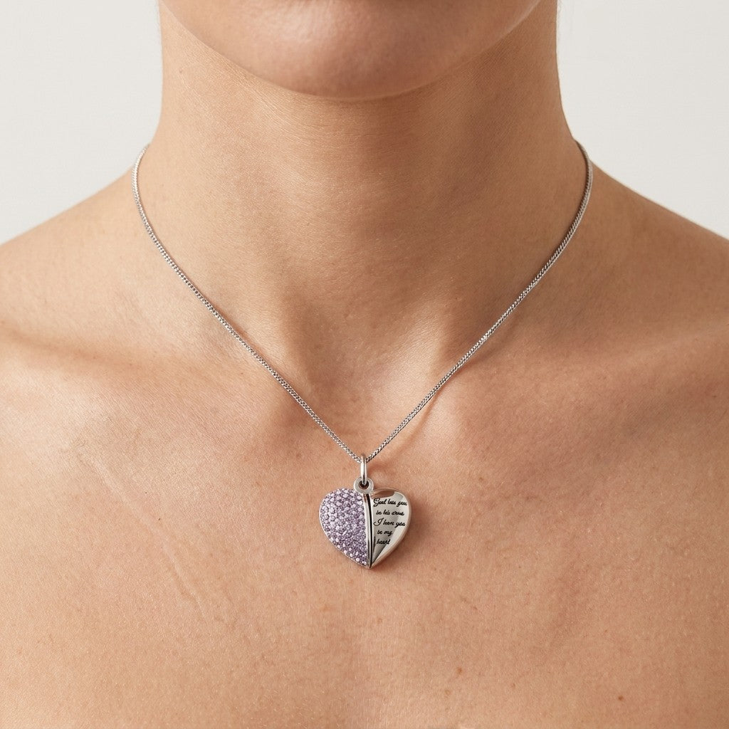 Aramat Jewels stalen hartvormige ashanger met lila kristallen en tekst "God has you in his arms, I have you in my heart".