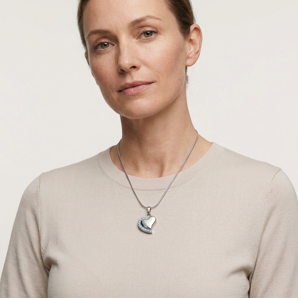 Aramat Jewels® zilverkleurige stalen hartvormige ashanger met zirkonia, gedragen door een vrouw.
