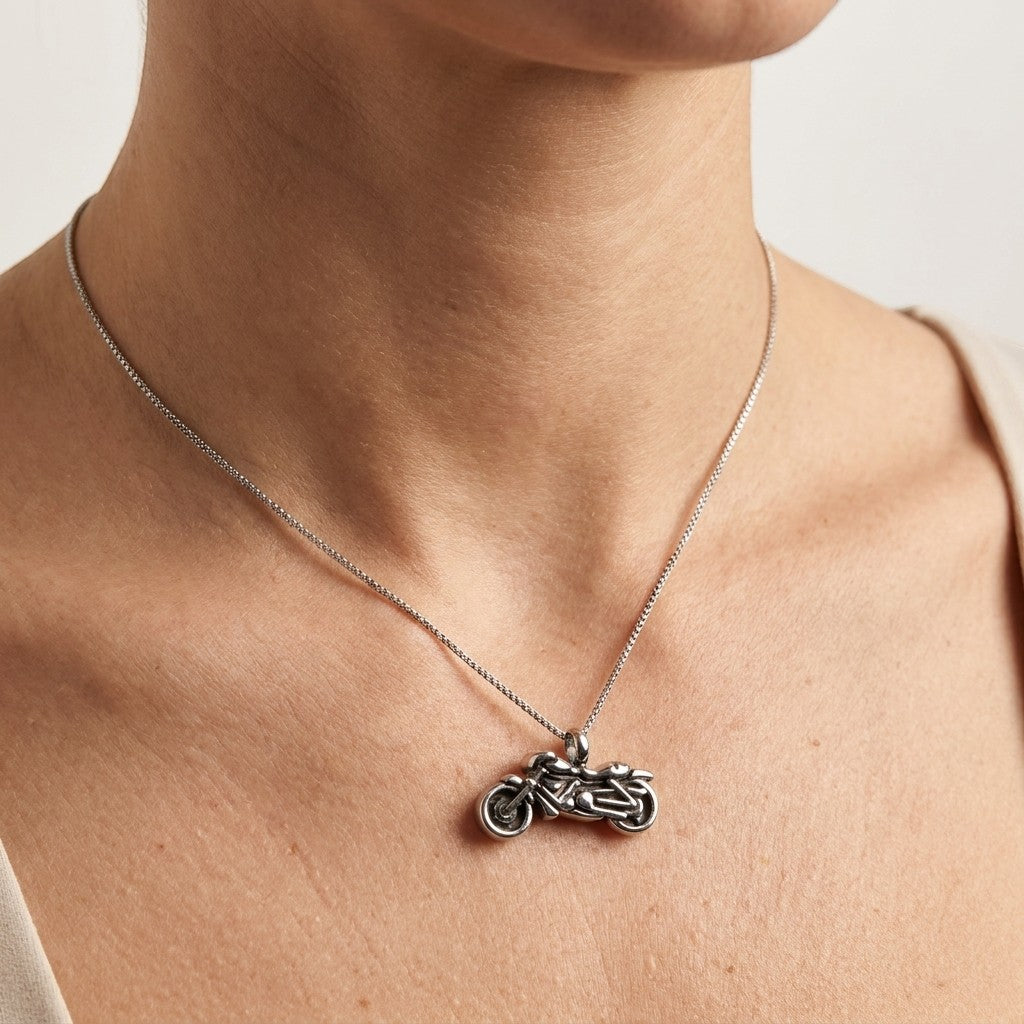 Aramat Jewels stalen ashanger in de vorm van een motor, gedragen aan een zilverkleurige ketting.