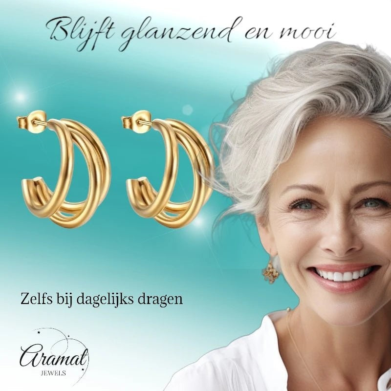 Aramat Jewels goudkleurige triple halve oorringen van roestvrij staal met vlindersluiting, gedragen door een model.