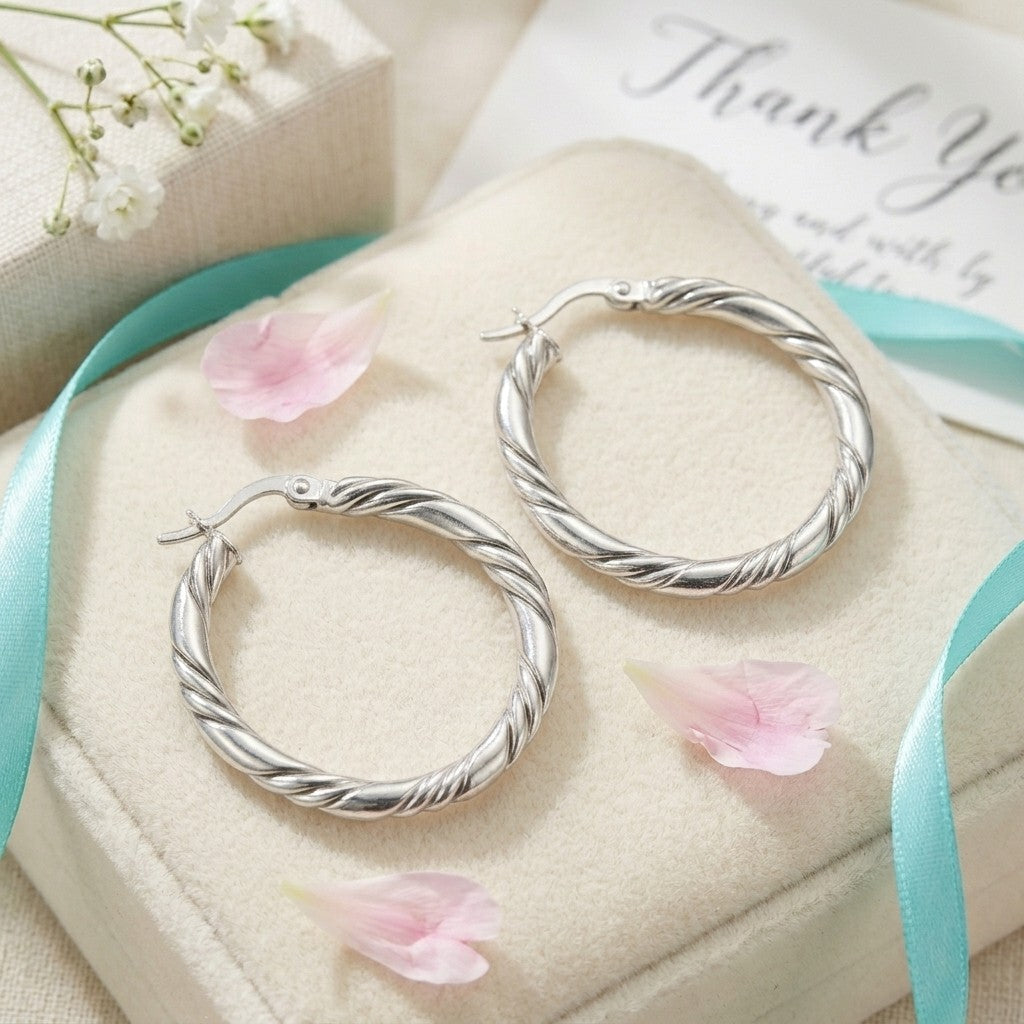 Aramat Jewels silver-coloured stainless steel twisted hoop earrings, 30mm diameter, with a 3-thread design.