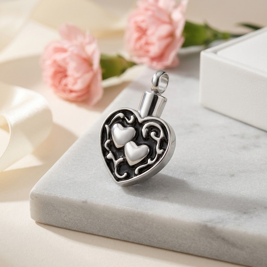 Aramat Jewels silver and black stainless steel cremation pendant with two hearts design, 30x18mm.