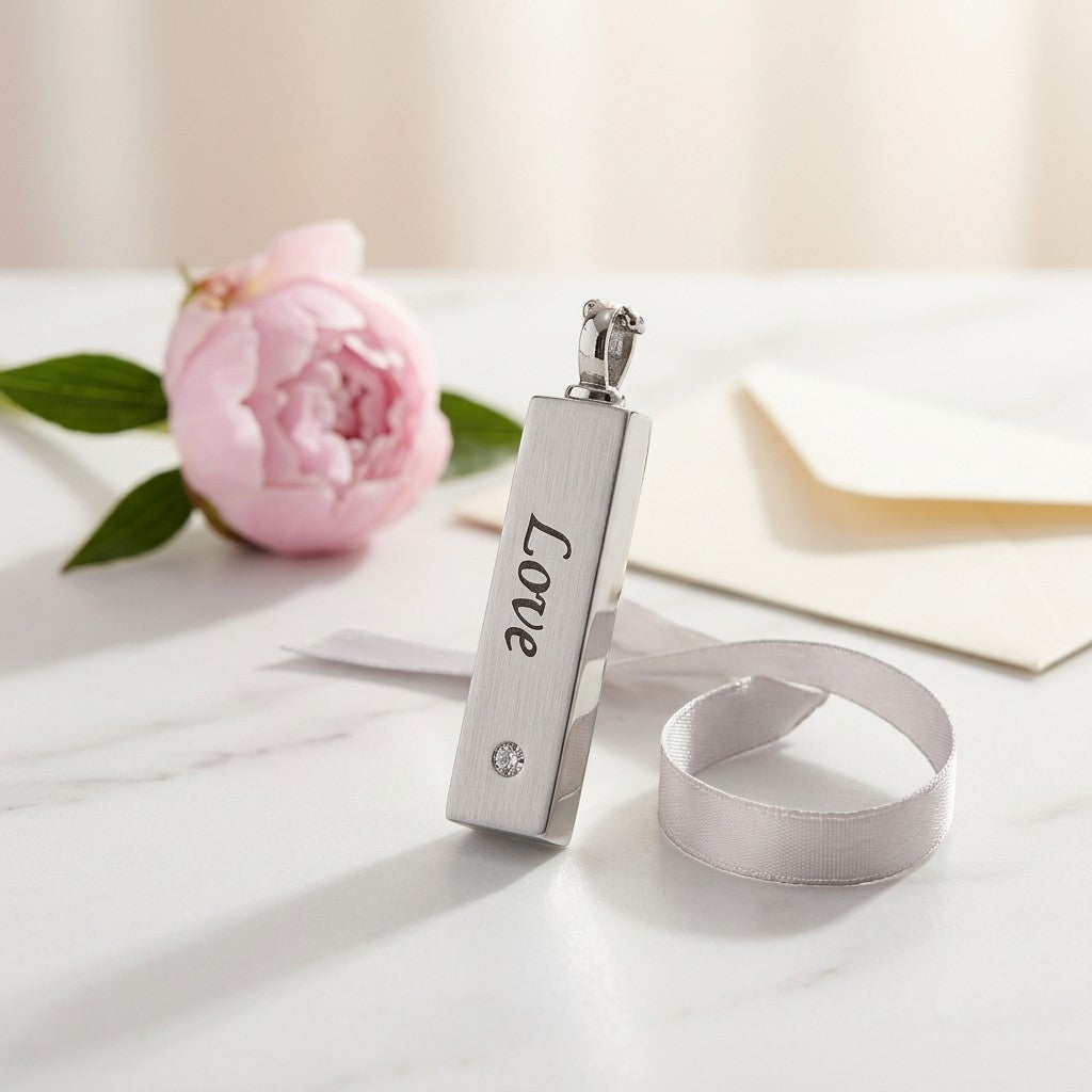 Aramat Jewels vierkante buis ashanger van RVS in zilverkleur met de tekst 'Love' en een zirkonia. Een romantisch gedenksieraad.