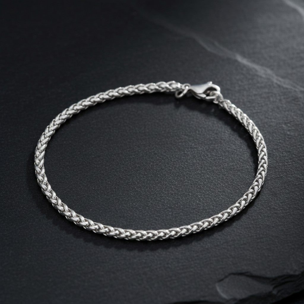 Aramat Jewels vossenstaart armband van zilverkleurig RVS met een verfijnde schakel op een donkere ondergrond.