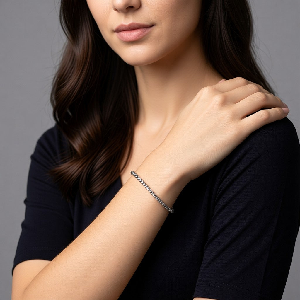 Aramat Jewels vossenstaart armband van zilverkleurig RVS gedragen door een vrouw met een zwart shirt.