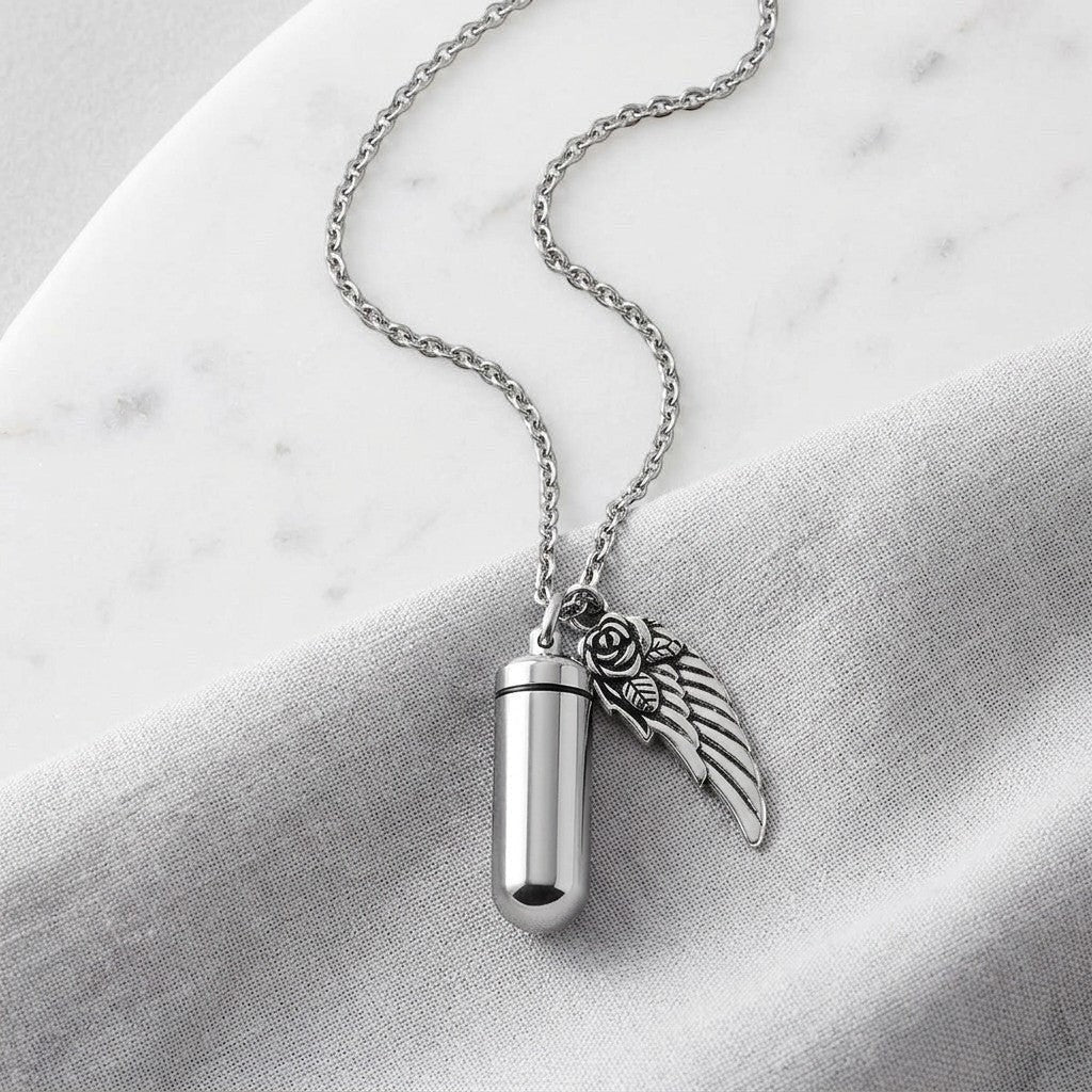 Aramat Jewels zilverkleurige ashanger met vleugel en roos, van roestvrij staal. Gedenksieraad met schroefsluiting.