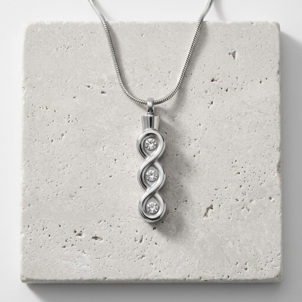 Aramat Jewels zilverkleurige stalen crematiehanger met transparante details en een infinity design.