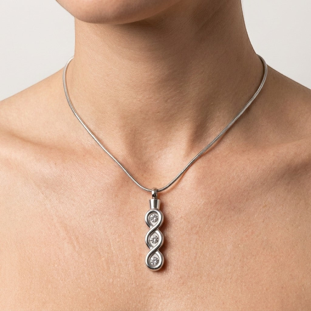 Aramat Jewels® zilverkleurige stalen crematiehanger met transparante details en drie cirkelvormige gravures.