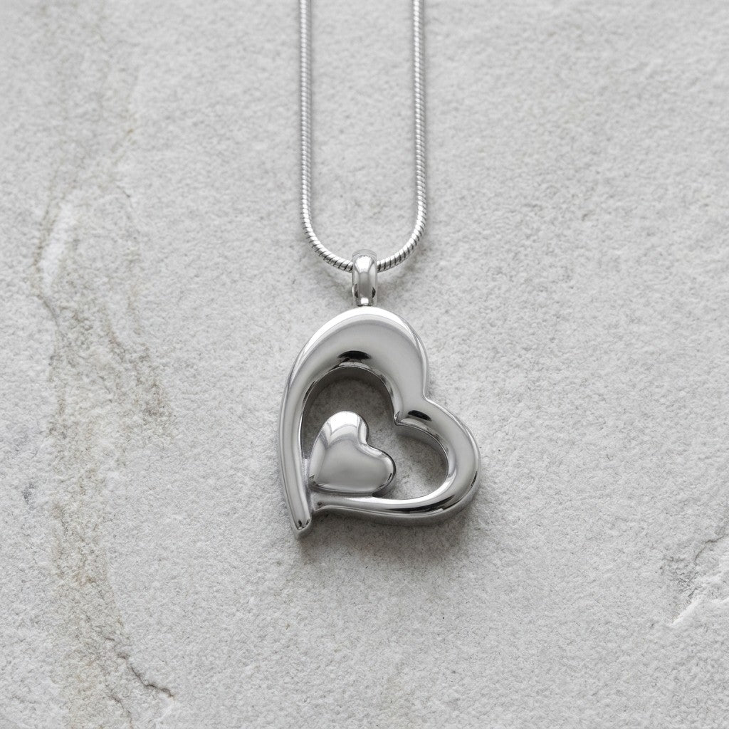 Aramat Jewels® zilverkleurige stalen ashanger in hartvorm met een kleiner hartje erin. Zonder ketting.