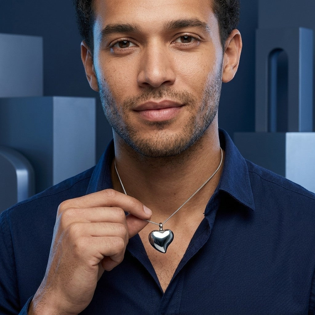 Aramat Jewels zilverkleurige hartvormige crematiehanger van roestvrij staal, gedragen door een man.