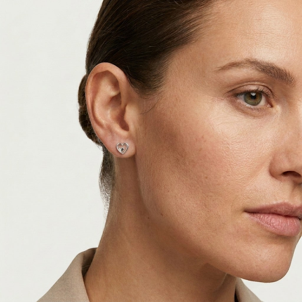 Aramat Jewels zilverkleurige oorstekers met een open en gesloten hartje, gemaakt van RVS.
