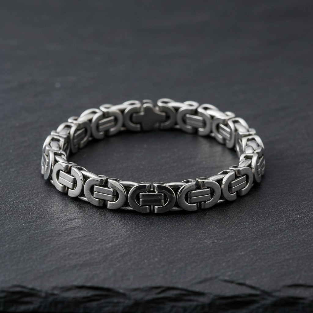 Aramat Jewels zilverkleurige stalen koningsschakelarmband van 22 cm breed en 11 mm dik op een zwarte ondergrond.
