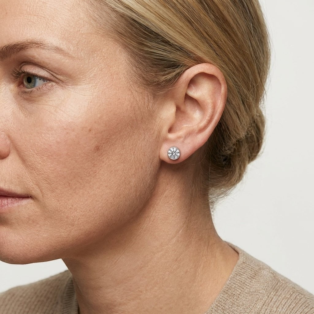 Aramat Jewels zilverkleurige oorstekers met 6mm transparant kristal, gemaakt van roestvrij staal.