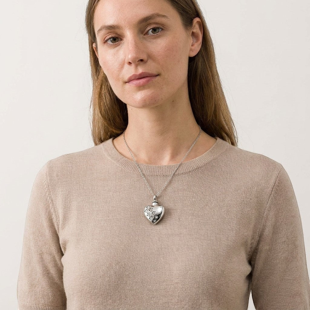 Aramat Jewels® zilverkleurige stalen ashanger in hartvorm met zirkonia pootjes, gedragen door een model.