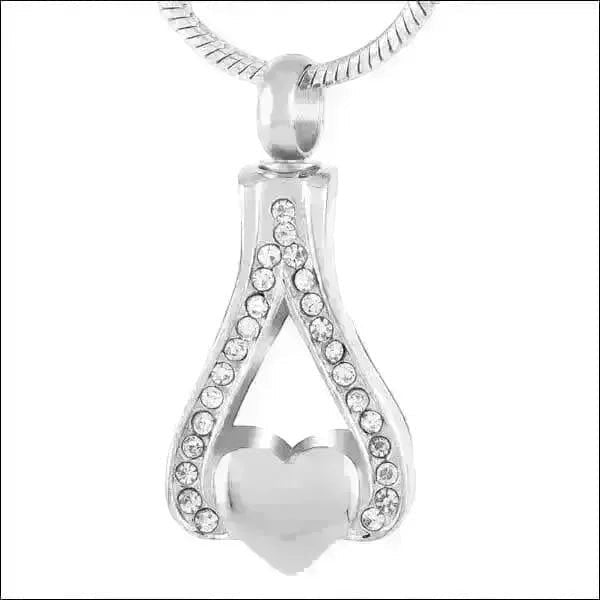 Aramat Jewels zilverkleurige stalen ashanger in hartvorm, versierd met kristallen. Een subtiel gedenksieraad.