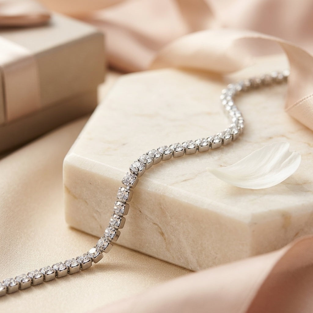 Aramat Jewels zilverkleurige stalen tennisarmband met fonkelende zirkonia stenen op een marmeren ondergrond.