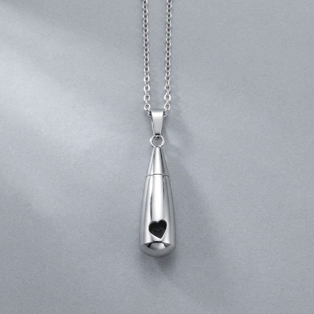 Aramat Jewels zilverkleurige RVS druppelvormige ashanger met opengewerkt hartje, 3,1cm lang, met schroefsluiting.