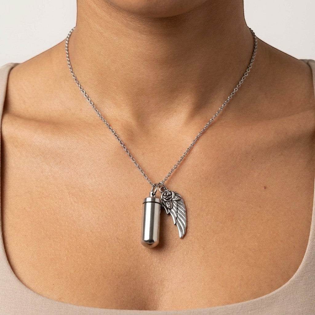 Aramat Jewels zilverkleurige ashanger met vleugel en roos, van roestvrij staal. Gedenksieraad met schroefsluiting.