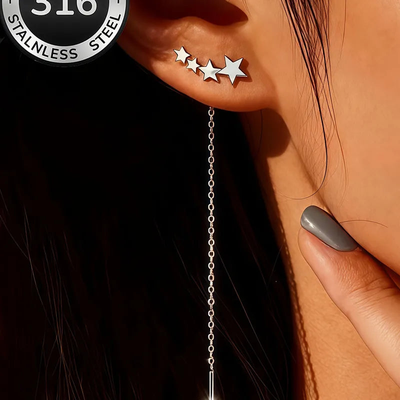 Aramat Jewels zilverkleurige doortrek oorbellen van RVS met een rij sterretjes gedragen in een oor