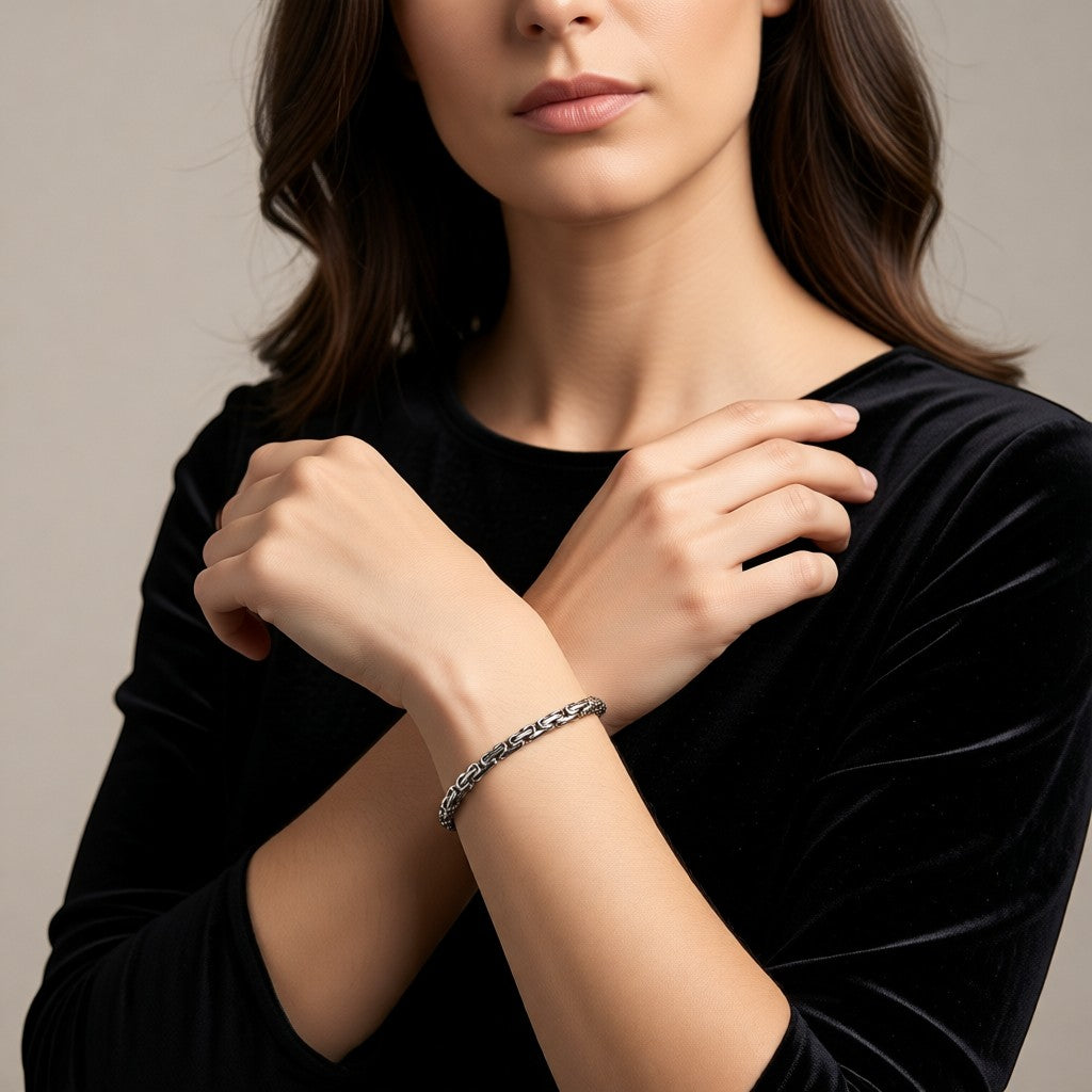 Aramat Jewels zilverkleurige RVS koningsschakel armband van 5mm breed gedragen door een vrouw in een zwarte top.