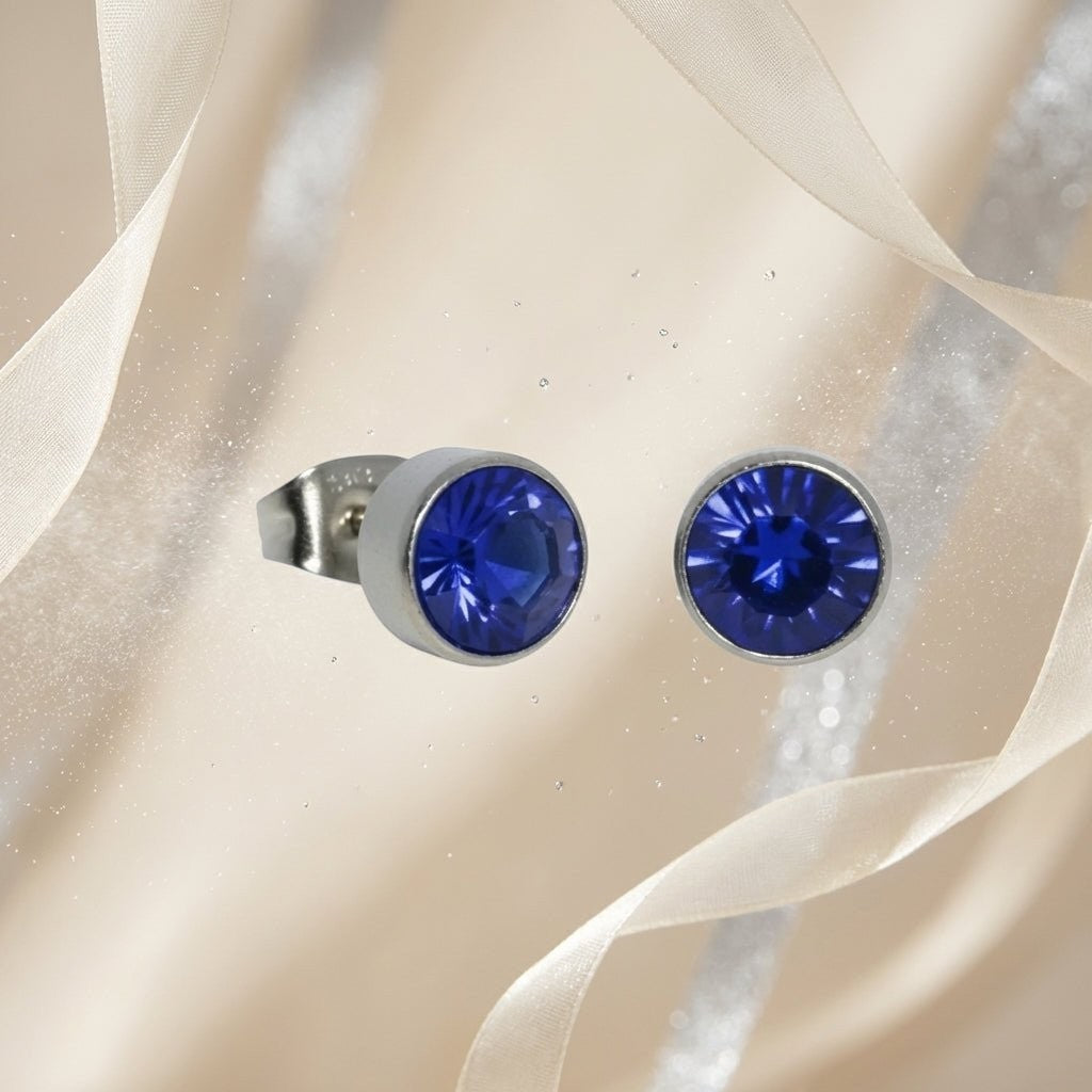 Aramat Jewels zilverkleurige oorstekers met donkerblauw kristal van 7mm, gemaakt van roestvrij staal.