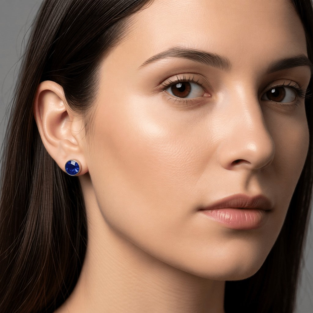 Aramat Jewels zilverkleurige oorstekers met een donkerblauw kristal van 7mm. Uniseks, gemaakt van roestvrij staal.