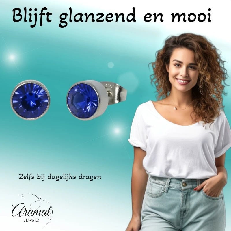 Aramat Jewels zilverkleurige oorstekers met 7mm donkerblauw kristal, gemaakt van roestvrij staal.